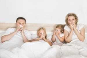 sick family lying in bed at home Family in bed with the flu