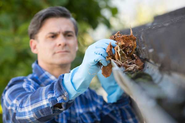 man cleaning gutters