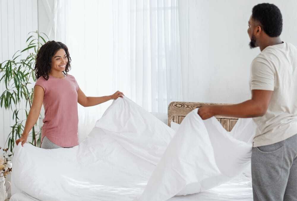 Happy,Married,African,Couple,Making,Bed,Together,In,The,Morning,